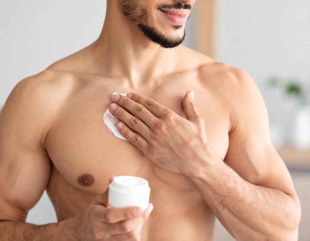 Man applying fragrance-free moisturizer to freshly shaved chest, highlighting post-shave skincare