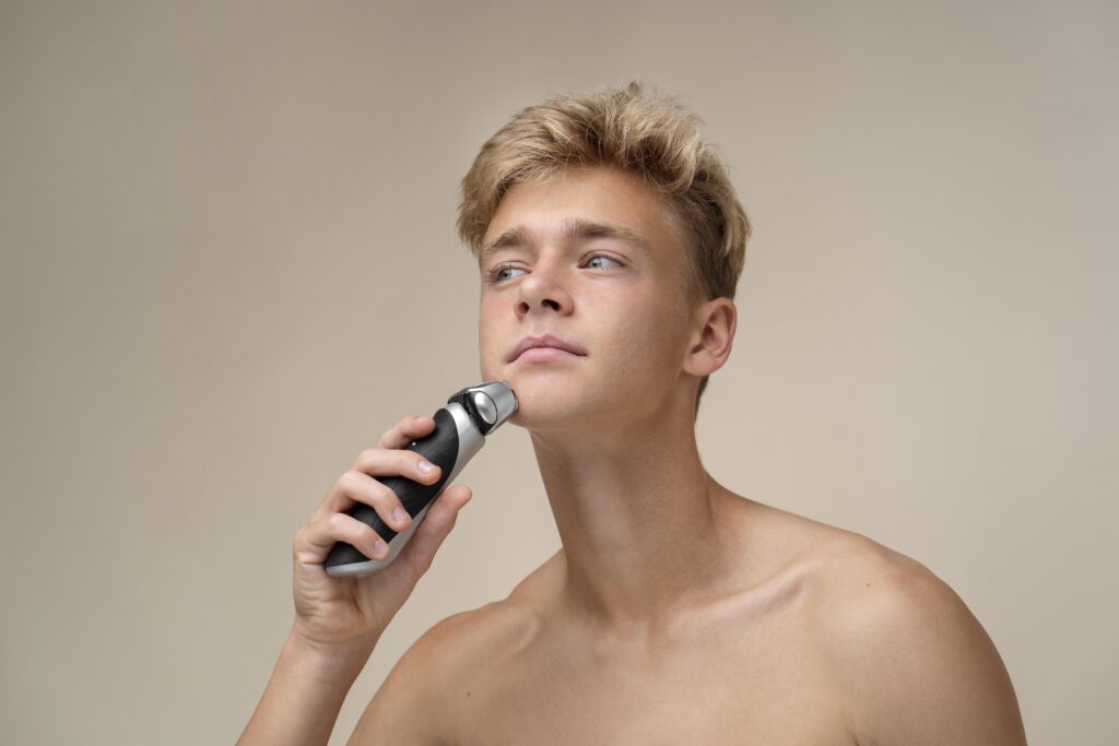 Close-up shot of a man's smooth jawline after shaving, with a modern foil shaver resting on a clean bathroom shelf in the background